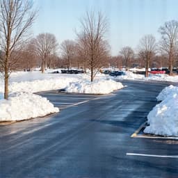 Commercial snow removal service in a Tucson parking lot. A clean and clear commercial parking area after efficient snow and ice removal, ensuring business accessibility.