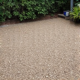 Before: Uneven and sparse gravel patio area in Green Valley requiring makeover. The image displays a residential patio area in Green Valley, AZ, with patchy, poorly distributed gravel and visible soil underneath.